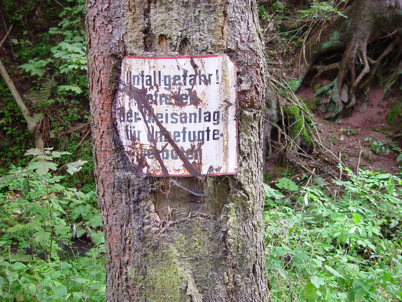 Warnschild, eingewachsen